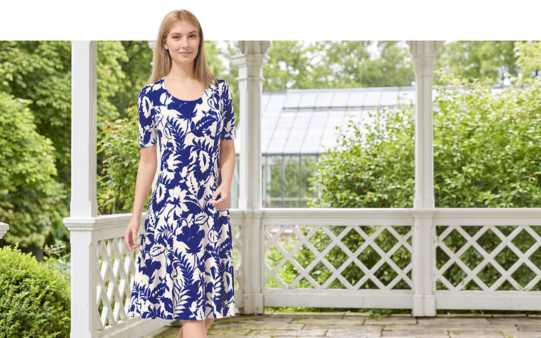 Dame in blau weiss gemustertem Kleid auf einer Veranda