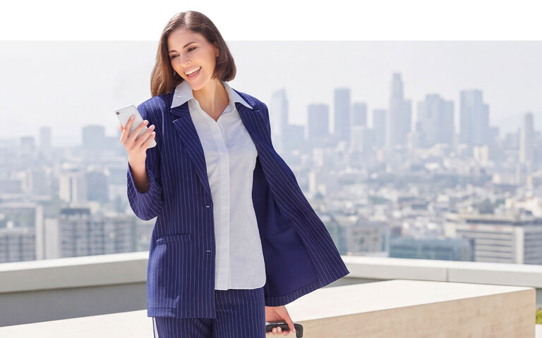 Dame in blauem Blazer vor einer Skyline