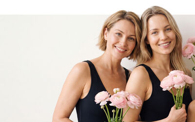 Zwei Damen mit Blumen in der Hand