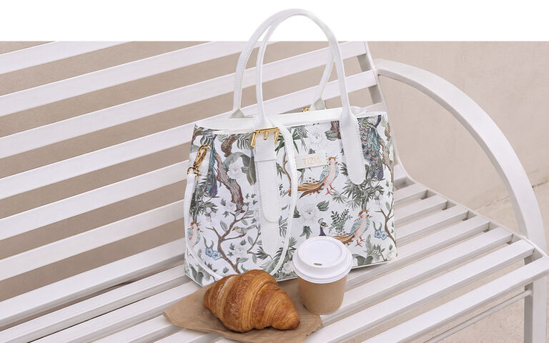 Hell gemusterte Handtasche auf einer Bank